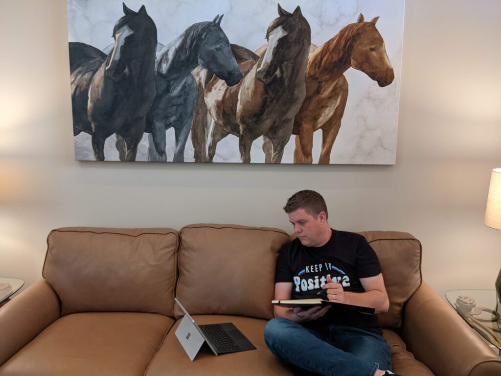 The Positivity Project is an upcoming book published by Situation Positive that features the real-life stories of people living their best life with chronic illness. The picture features Matt Cavallo sitting on a couch taking notes while looking at his computer.