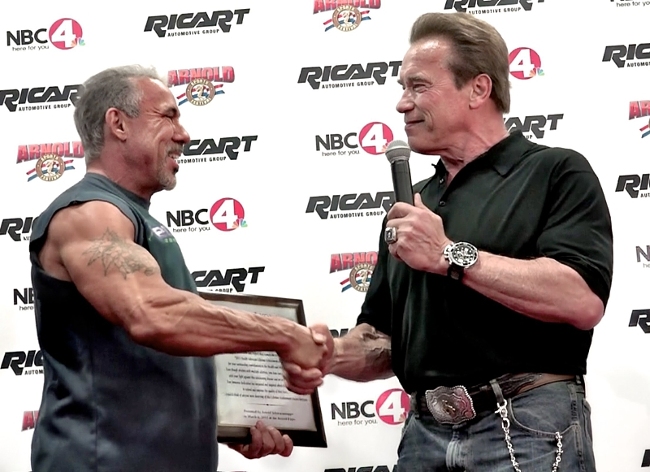 David receiving an award from Arnold Schwarzenegger.